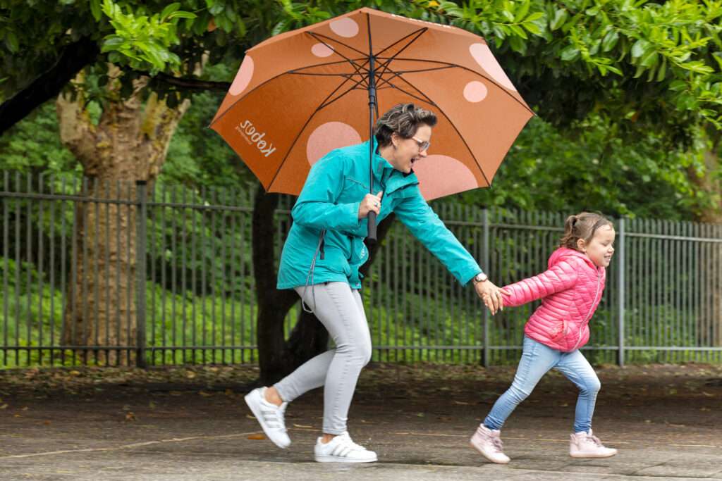 Pedagogisch medewerker paraplu en kind