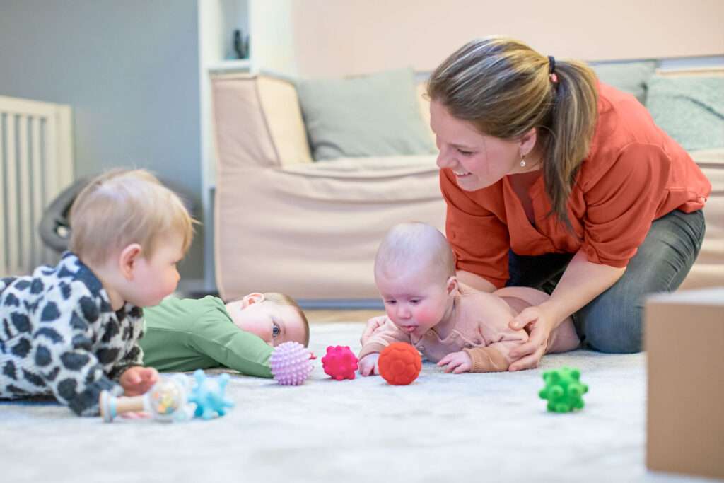 Pedagogisch medewerker speelt met baby's