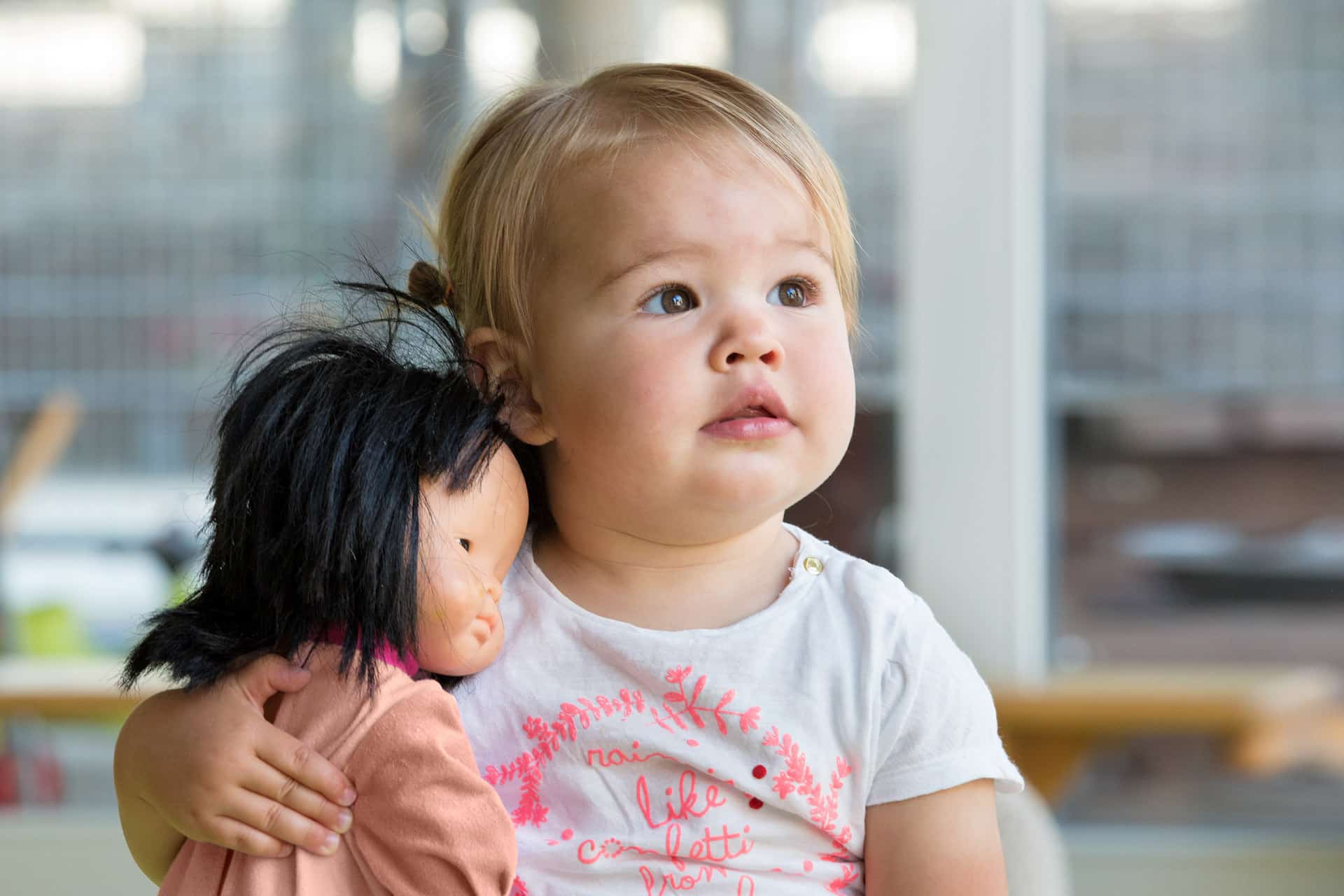Baby speelt met pop bij Kober Kinderopvang